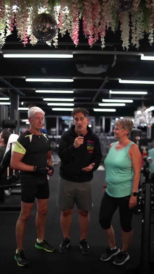 Ein Trainer im Gespräch mit Claudia und Frank auf der Trainingsfläche